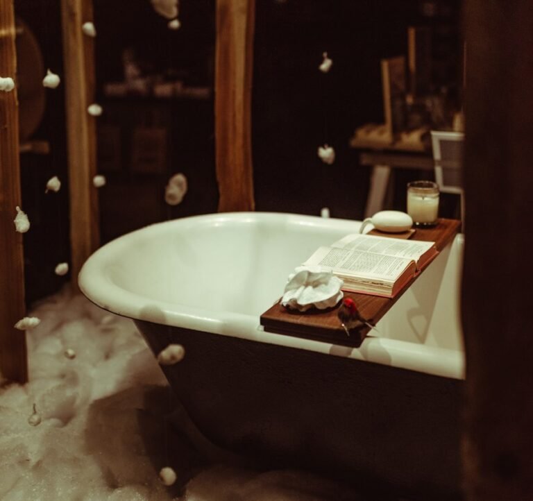 Clawfoot tub with a bath tray in a moody bathroom
