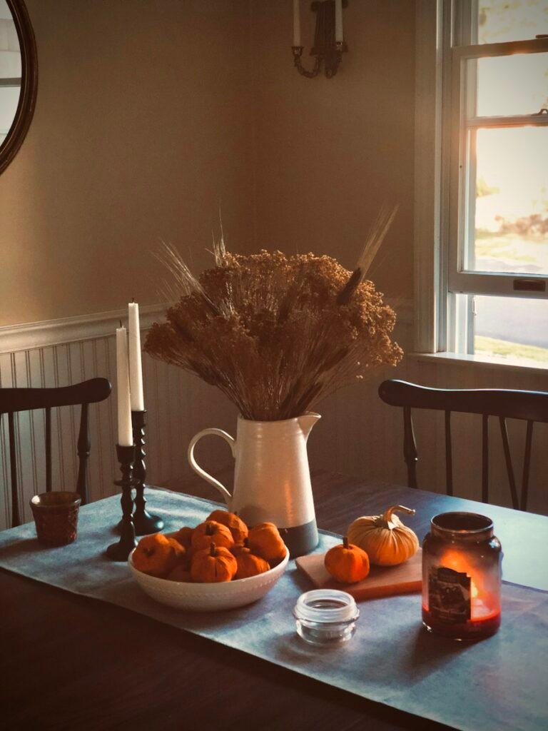 Kitchen table with candles, dried flowers and oranges